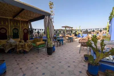 a patio with chairs and tables and cactuses at Riad Salma Restaurant Spa in Marrakech