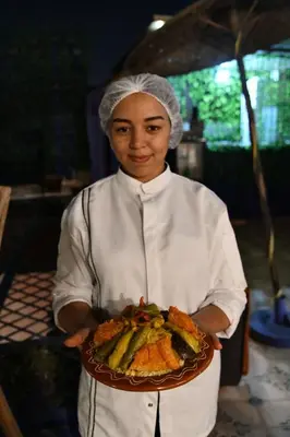 a woman is holding a plate of food at Riad Salma Restaurant Spa in Marrakech