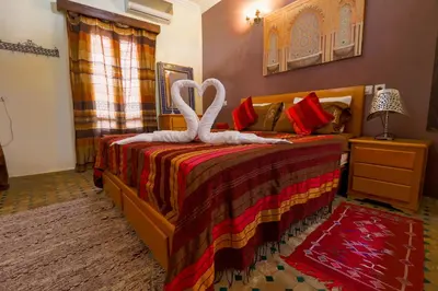 a bedroom with a bed with a swan on it at Riad Salma Restaurant Spa in Marrakech