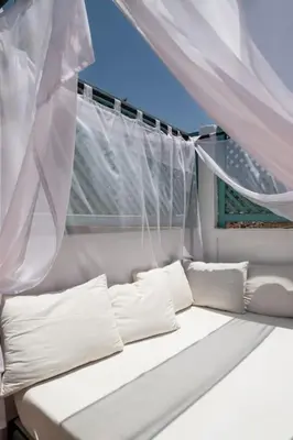 a white couch in a window with white curtains at Riad Al Tainam in Marrakech