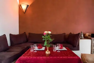 a living room with a couch and a table with flowers at Riad Al Tainam in Marrakech