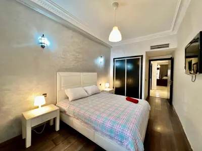 a bedroom with a bed and a table with two lamps at Sabor Apartments Anas Majorelle in Marrakech