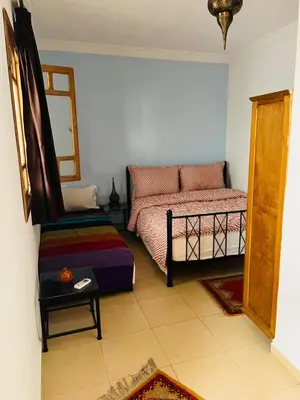 a bedroom with a bed and a chair in it at Hostel Amour d'auberge in Marrakech