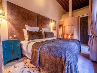 a bedroom with a large bed with a blue night stand at Riad Ines Home in Marrakech