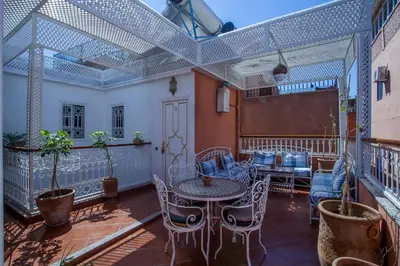 a balcony with a table and chairs and a chalkboard at Hotel Zitoune in Marrakech