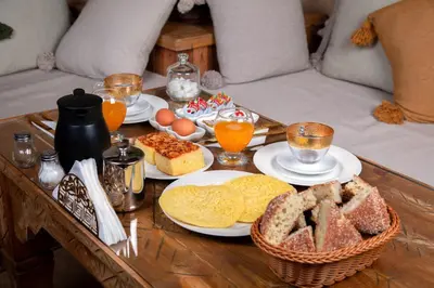 a coffee table with plates of bread and eggs on it at Riad Miss Caracal in Marrakech