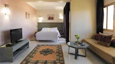 a hotel room with a bed and a couch at Appart-Hotel Amina Resort & Spa in Marrakech