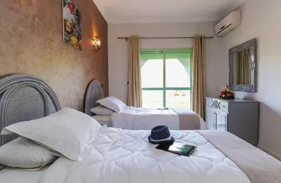 a bedroom with two beds with a hat on top at In Club Palmeraie Resorts in Marrakech
