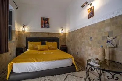 a bedroom with a bed with a yellow bedspread at Riad Ciel d'Orient in Marrakech
