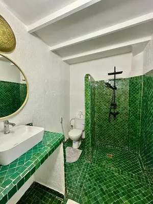 a green tiled bathroom with a sink and a toilet at Riad Green Vines in Marrakech