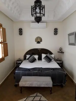 a bedroom with a large bed and a chandelier at Riad Safina in Marrakech