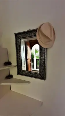 a mirror on a wall with a hat on it at Riad Safina in Marrakech