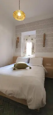 a bedroom with a large white bed with a pillow on it at Dar Andamaure in Marrakech