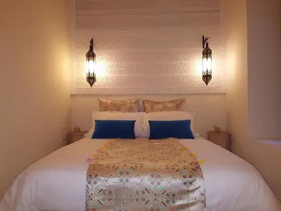 a bedroom with a large white bed with blue pillows at Dar Andamaure in Marrakech
