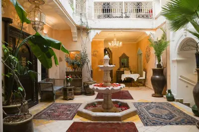 a living room with a fountain in the middle of a room at Riad Palais Des Princesses & Spa in Marrakech
