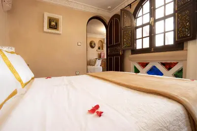 a bedroom with a large white bed with red bows on it at Riad Palais Des Princesses & Spa in Marrakech