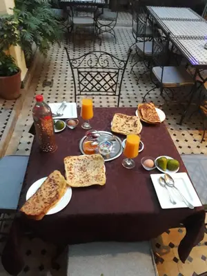 a table with plates of food and glasses of orange juice at Les Rêves De Marrakech in Marrakech