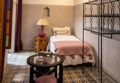 a bedroom with a bed and a table with glasses on it at Riad Zayane Atlas in Marrakech