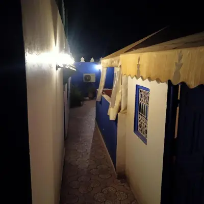 a narrow alley with blue and white buildings at night at Riad Tifor in Marrakech