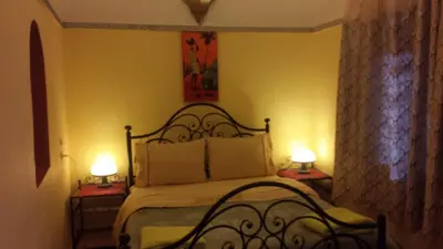 a bedroom with a bed with two lamps on tables at Riad Tifor in Marrakech