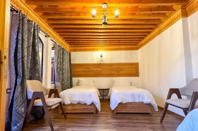 two beds in a room with wooden ceilings at Riad Dar Moulay Ali in Marrakech