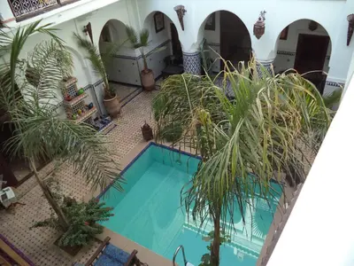 an overhead view of a swimming pool with palm trees at Riad Dar Moulay Ali in Marrakech