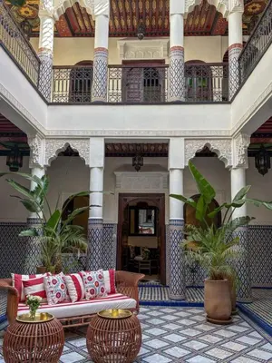 a lobby of a building with a couch and two tables at Riad Yakimour in Marrakech