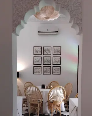 a dining room with a table and chairs at Riad Yakimour in Marrakech