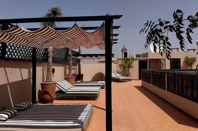 a row of chaise lounges on a patio at Riad Yakimour in Marrakech