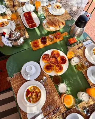 a long table with plates of food on it at Riad Yakimour in Marrakech