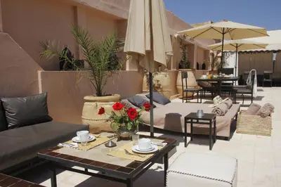 a living room with a couch and tables and an umbrella at Riad Utopia Suites And Spa in Marrakech