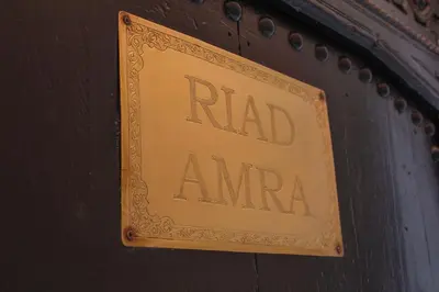 a sign that reads ra mend amara on a wall at Riad Amra in Marrakech