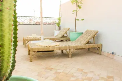 two wicker chairs and a table on a patio at Riad Amra in Marrakech