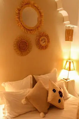 a bedroom with two mirrors and a bed with pillows at Riad Amra in Marrakech