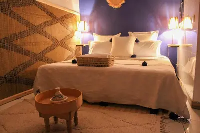 a bedroom with a large bed and a table at Riad Amra in Marrakech