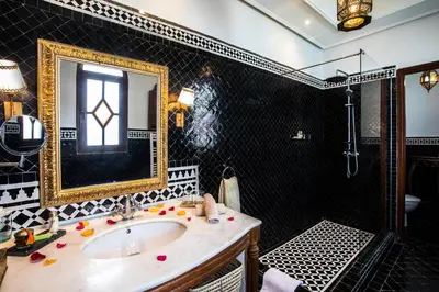 a bathroom with a sink and a shower with a mirror at Riad Ayadina & SPA in Marrakech