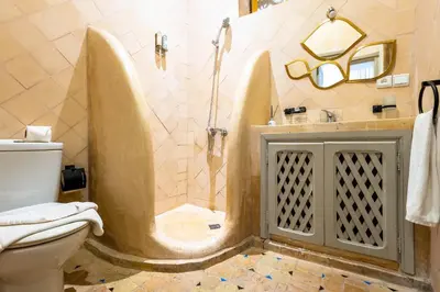 a bathroom with a shower with a toilet and a sink at Riad La Croix Berbere in Marrakech
