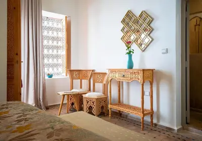 a bedroom with a table and two chairs and a table with a mirror at Riad La Croix Berbere in Marrakech