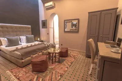 a bedroom with a bed and a table in a room at Le Medina Privilège Riad & Spa in Marrakech