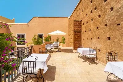 a patio with tables and chairs and a building at Le Medina Privilège Riad & Spa in Marrakech
