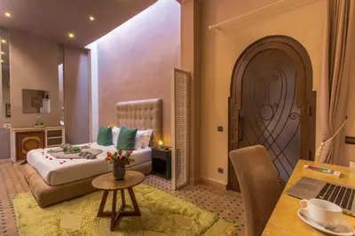 a bedroom with a bed and a table with a laptop at Le Medina Privilège Riad & Spa in Marrakech