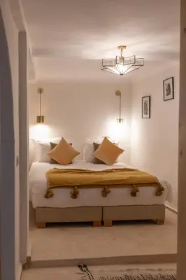 a bedroom with a bed with white sheets and pillows at Riad N'S & Spa in Marrakech