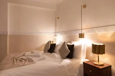 a bedroom with a bed with white sheets and pillows at Riad N'S & Spa in Marrakech