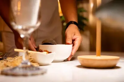 a person preparing food in a bowl on a table at Riad Les Orangers D'alilia in Marrakech