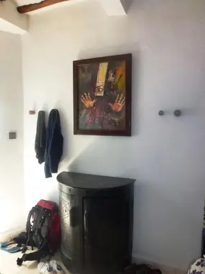 a painting hanging on a wall above a trash can at Ryad Laârouss Family in Marrakech