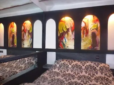 a room with two beds and a painting on the wall at Ryad Laârouss Family in Marrakech