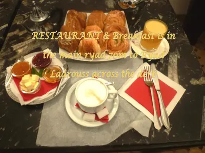 a table with a plate of pastries and a cup of coffee at Ryad Laârouss Family in Marrakech