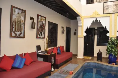 a living room with two red couches and a pool at Riad des Etoiles in Marrakech