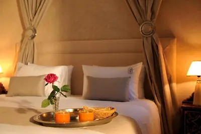a tray with a rose and candles on a bed at Riad Le Jardin d'Abdou in Marrakech