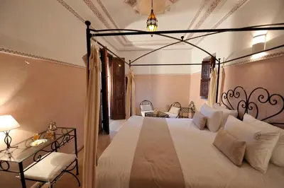 a bedroom with a large white bed and a lamp at Riad Le Jardin d'Abdou in Marrakech